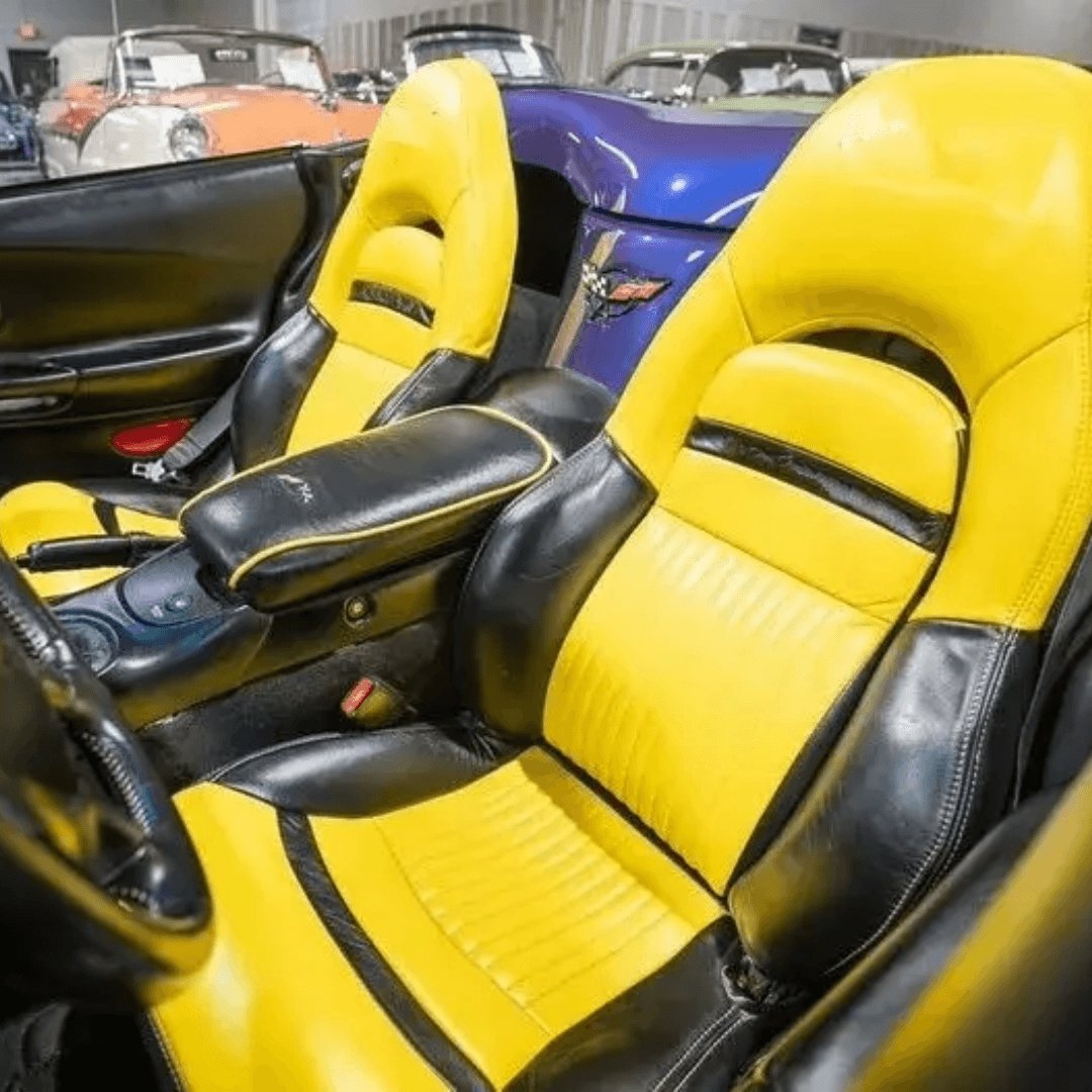 Corvette C5 interior with black and yellow leather seat covers featuring the Corvette emblem. The vibrant yellow and sleek black design enhance the sporty and luxurious feel of the car's cabin, providing a striking and comfortable upgrade. Detailed views showcase the high-quality materials and craftsmanship, adding a bold and eye-catching look to the vehicle's interior.