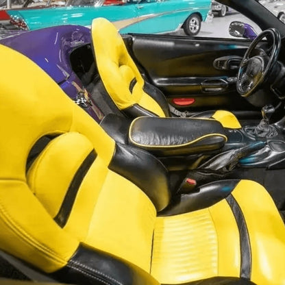 Corvette C5 interior with black and yellow leather seat covers featuring the Corvette emblem. The vibrant yellow and sleek black design enhance the sporty and luxurious feel of the car's cabin, providing a striking and comfortable upgrade. Detailed views showcase the high-quality materials and craftsmanship, adding a bold and eye-catching look to the vehicle's interior.