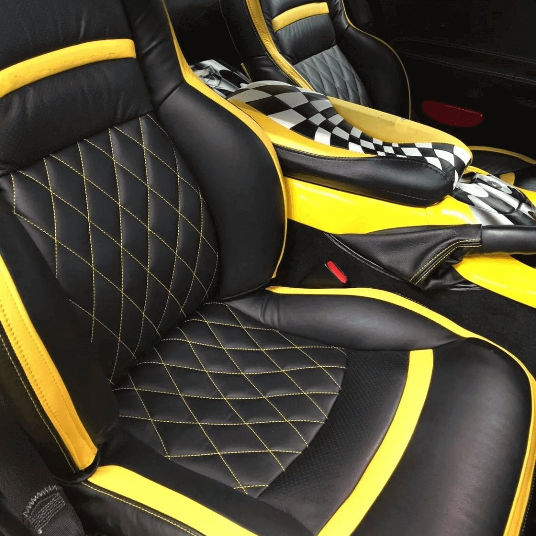 Corvette C5 seat covers in black faux leather with yellow accents and diamond-stitched patterns on the seat and backrest. The seat covers feature a sleek, sporty design that complements the Corvette's interior. The stitching and material add a luxurious touch, enhancing both comfort and aesthetics.nd aesthetics."