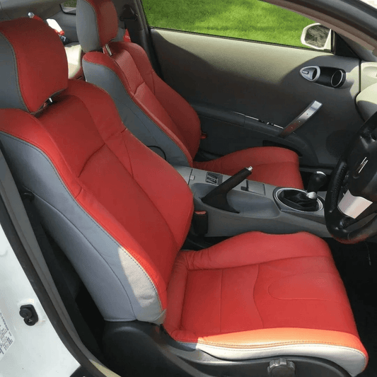 Front seats of Nissan 350Z featuring custom red and gray leather seat covers with a modern two-tone design, tailored for 2003-2008 models.