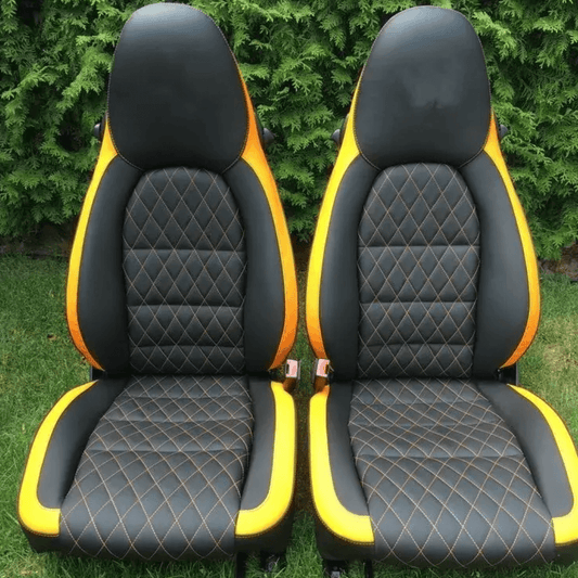 Custom Porsche Boxster 986 (1997-2004) seat covers in black and yellow leather with a diamond pattern and yellow stitching, designed for a bold and luxurious interior upgrade.