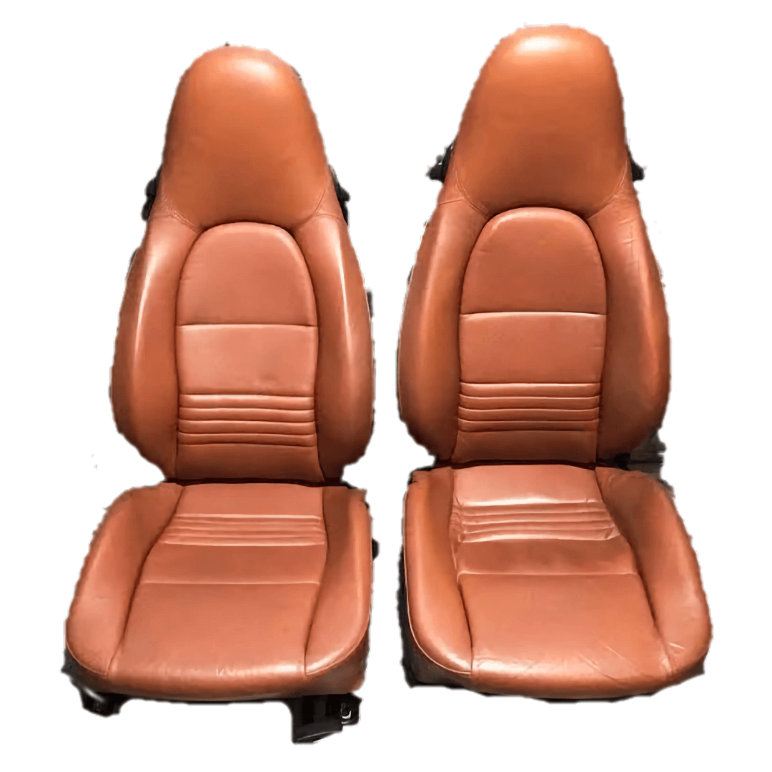 Burnt orange leather seat covers designed for Porsche Boxster 986 models from 1997 to 2004, showcasing the full set of driver and passenger seats with distinct stitching and contoured padding.