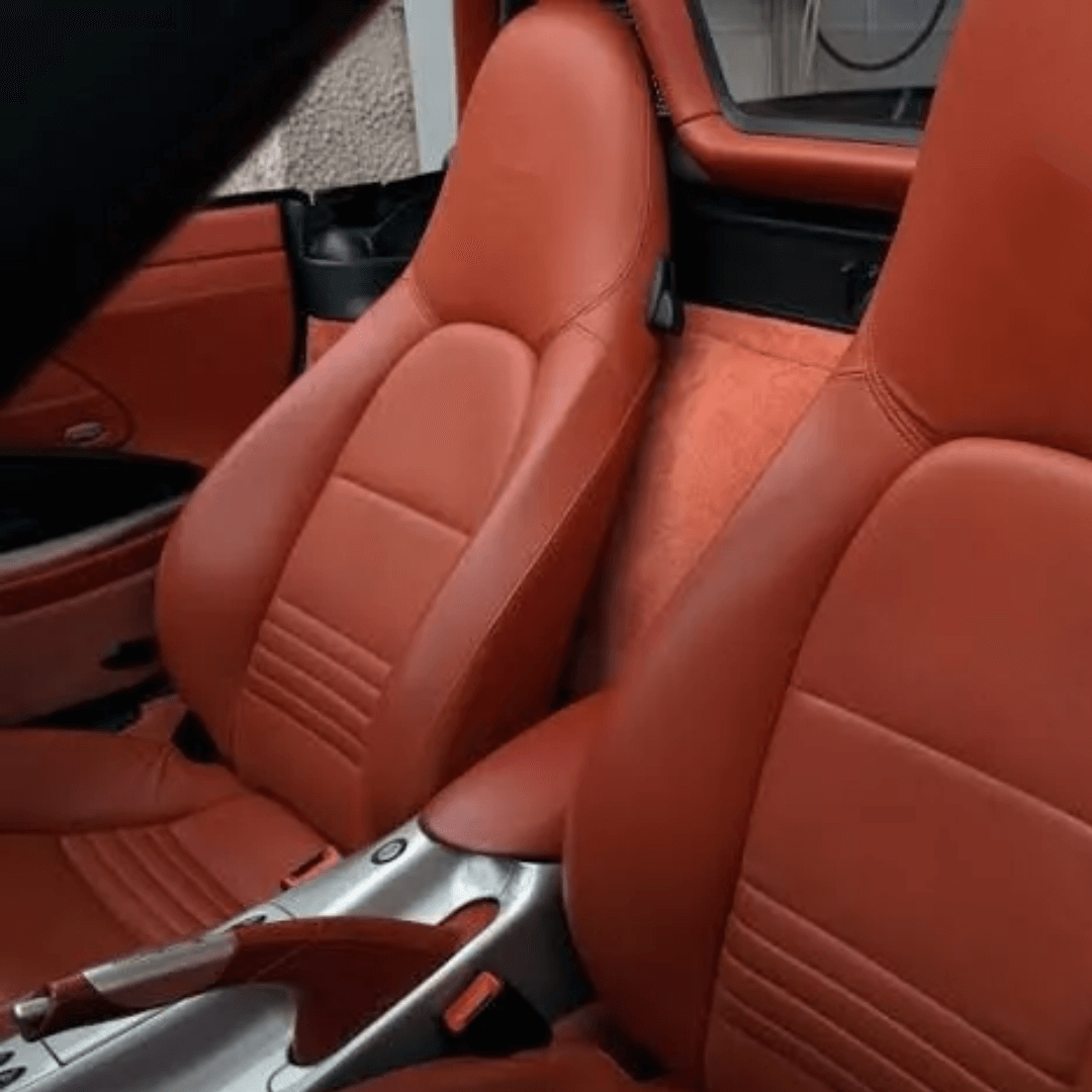 Close-up of Porsche Boxster 986 (1997-2004) seat covers in rich red leather, showcasing elegant design and perfect craftsmanship.